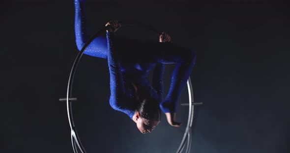 Young Lady in Blue Costume is Hanging on the Hoop and Doing Split Gymnastics