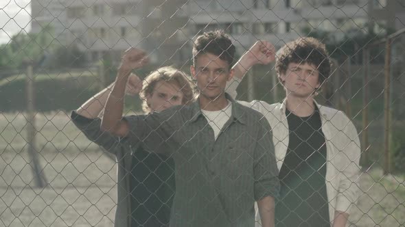 Three Serious Young Men Shaking Clenched Fists and Looking at Camera. Portrait of Group of