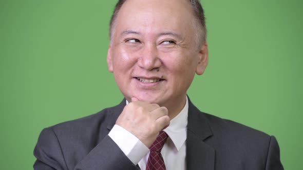 Mature Happy Japanese Businessman Smiling While Thinking