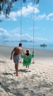 Couple Men and Woman on the Beach in Thailand with Swing on the Beach of Naka Island Phuket Thailand