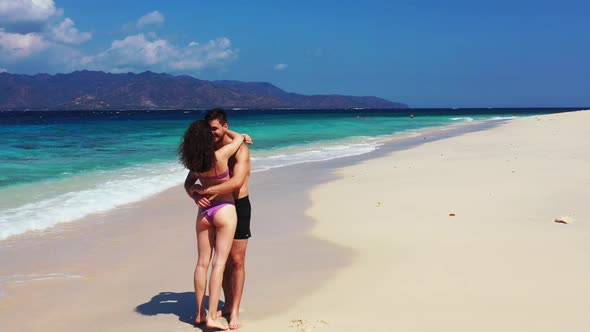 Family of two sunbathing on beautiful resort beach adventure by blue lagoon with white sandy backgro