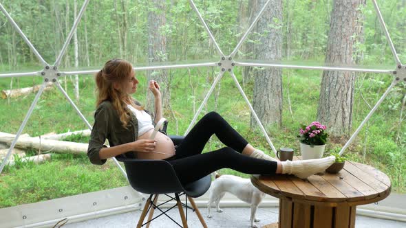 woman waiting with headphones on her stomach in a glamping tent