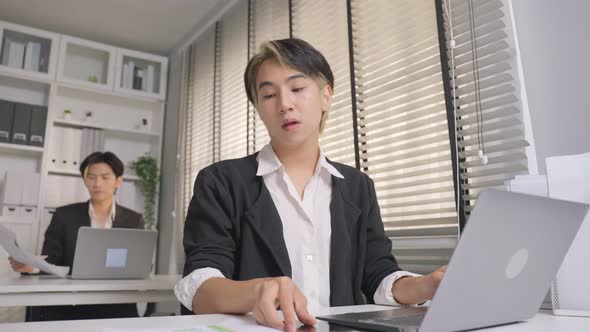 Asian handsome businessman gay people use laptop computer working in office with happiness