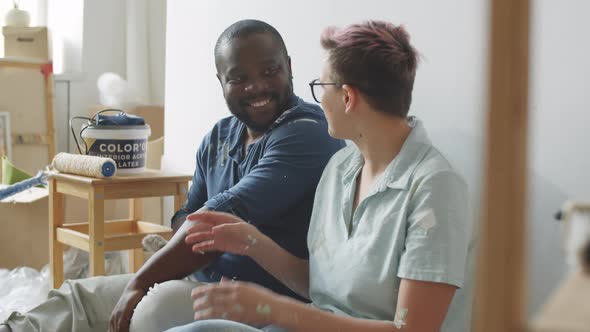 Multiethnic Couple Smiling at Camera while Renovating Room