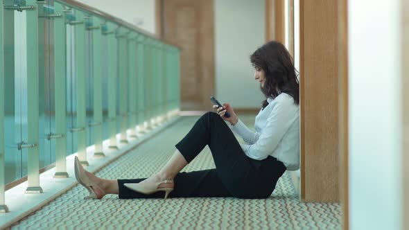 Business woman using phone. Corridor.