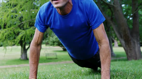 Mature man doing push-up in the park