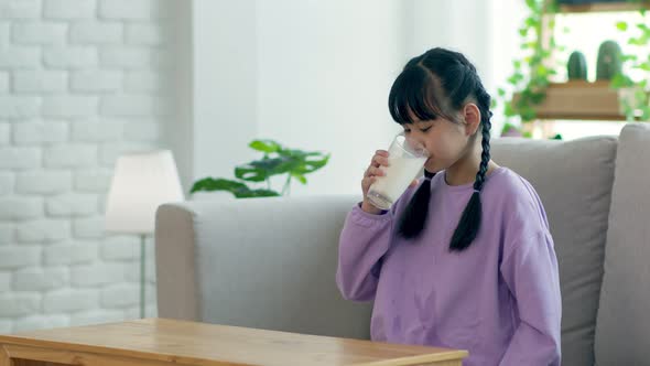 Slow motion of Happy asian Kid drinking fresh milk for good health at home