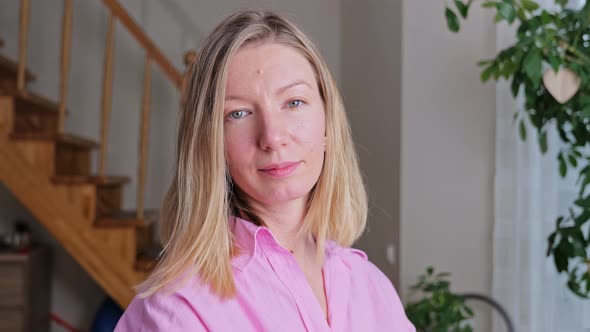 Closeup face of beautiful blond woman with blue eyes looking to camera