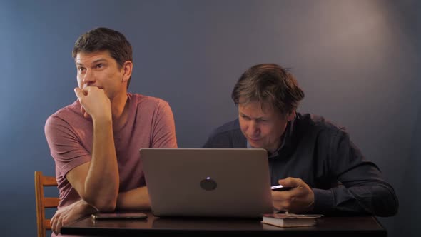 Man Shows How To Work with Laptop and Smartphone To Father