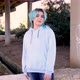 Smiling blue haired teenage girl wearing hoodie and staying against bridge pillars - VideoHive Item for Sale