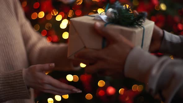 Close-up Hands of Caucasian Young Woman Giving Christmas Gift To African American Man, Slow Motion.