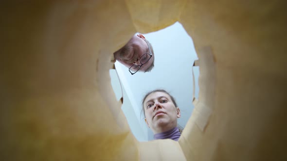 Woman And Man Children Peek Paper Bag Shopping Joyful Faces Close