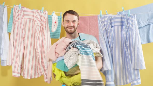 Happy Man with Stack of Dirty Clothes in Hands Looking at Camera