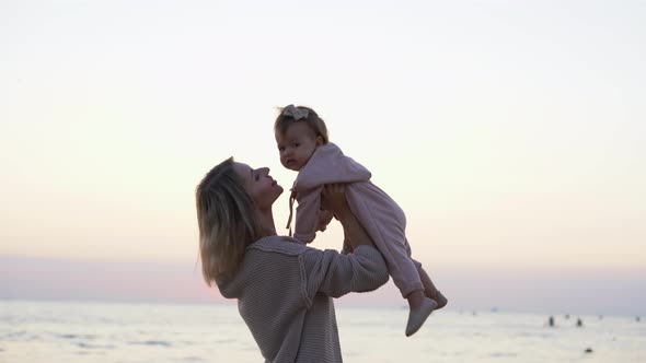 Happy Loving Family Mother and Daughter Have Fun on the Beach at Sunrise