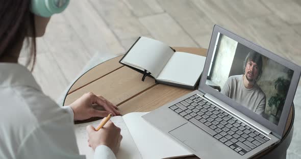 Young Woman Studying Online Using Laptop and Video Call with Teacher and Learning