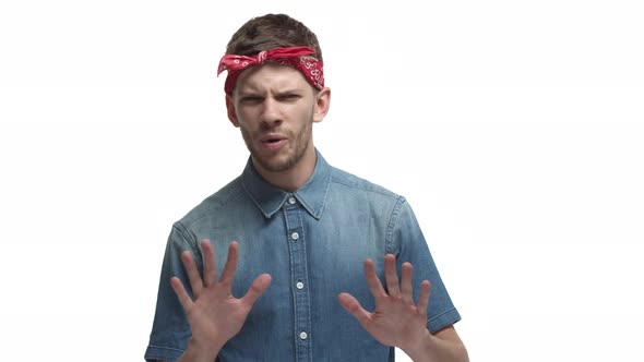 Handsome Bearded Male Hipster Wearing Red Headband Declining Something with Reluctant and Bothered