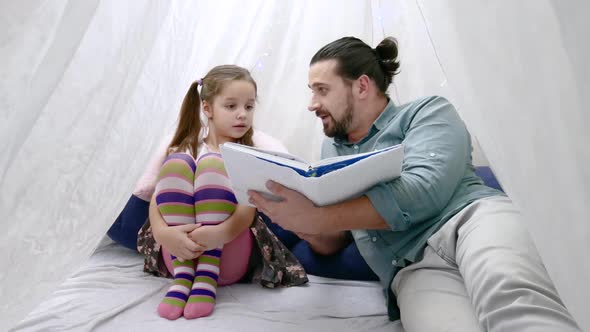 Little Girl and Her Father Reading a Book Together