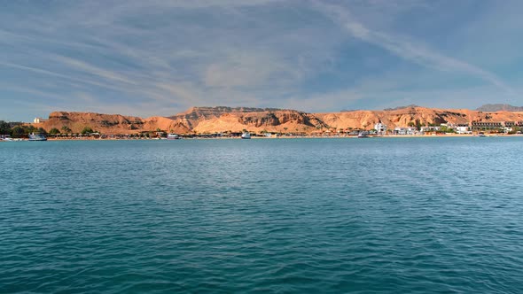 Tropical Landscape Blue, Turquoise Sea, Against the Yellow Coast of Desert Mountains. Palm Trees