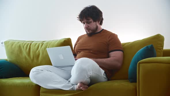 Man Freelancer Working at Home Using a Laptop