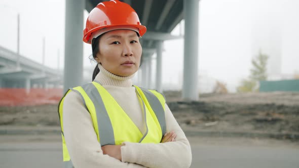 Portrait of Female Construction Engineer Asian Lady Standing in Building Area with Arms Crossed