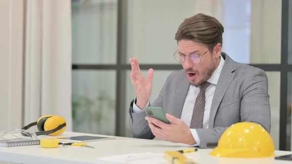 Upset Middle Aged Engineer Reacting to Loss on Smartphone