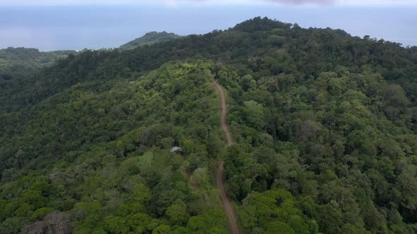 Aerial shot flying over tree covered mountains in Jaco, Costa Rica