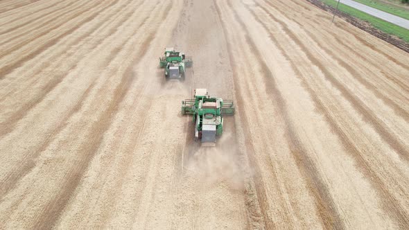 Aerial View of Harvester Machines Working in Wheat Field