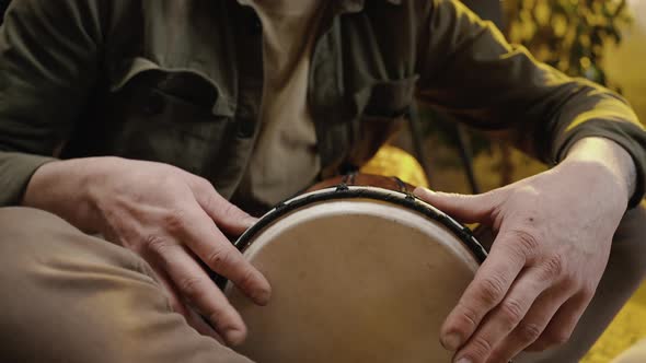Tracking Shot of Talented Man Musician Beating Drum Playing Music at Home Performing Rhythmic Sound