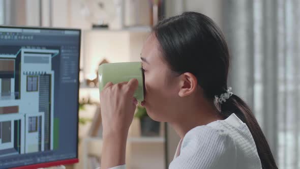 Close Up Of Asian Woman Engineer Drinking Coffee While Designing House On A Desktop At Home