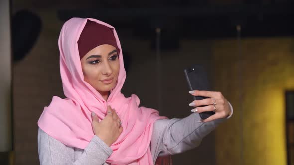 Young Beautiful Woman in Hijab Doing Selfie on Mobile Phone Camera. Muslim Woman and Modern