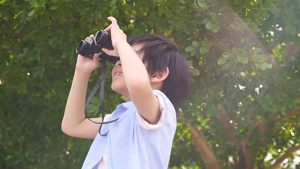 Cute Asian Child Using Binocular On Summer Day