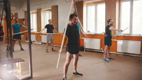 Men Training with the Crossbar in the Small Gym