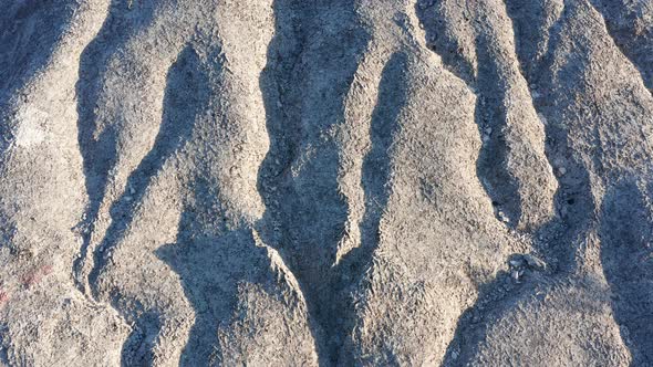 Bare wrinkled rock - texture of a rough stone with furrowed surface and without any vegetation