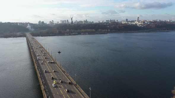 Urban Traffic on a Bridge Over a River. View of the Kiev Pechersk Lavra.