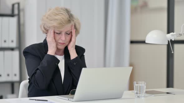 Old Businesswoman Having Headache While Working on Laptop