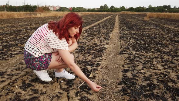 Girl Touches Dry and Burnt Ground