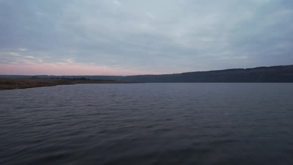 the Drone Flies in the Morning on River at High Speed Very Close to the Water