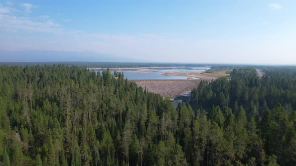 Aerial view of the Island park dam in Idaho.  Floating over the pine trees.