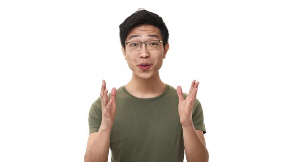 Portrait of Astonished Chinese Man Wearing Glasses and Basic Tshirt Rejoicing and Saying Wow in