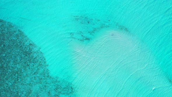 Wide fly over travel shot of a sunshine white sandy paradise beach and turquoise sea background in c