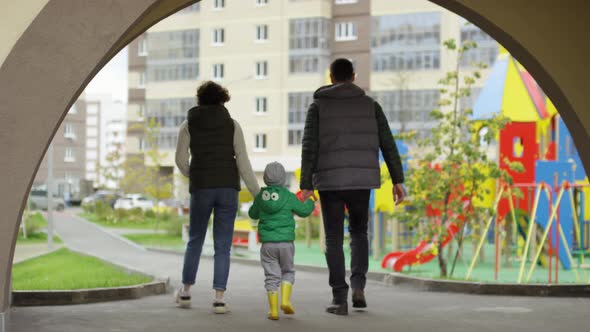 Young Parents and Son Returning from Outdoor Walk alt