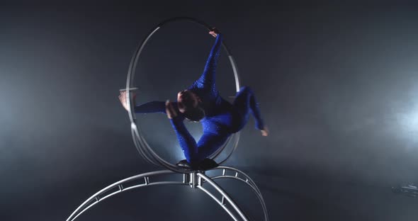 Flexible Woman in Blue Costume is Doing Gymnastics in a Hoop on Stage