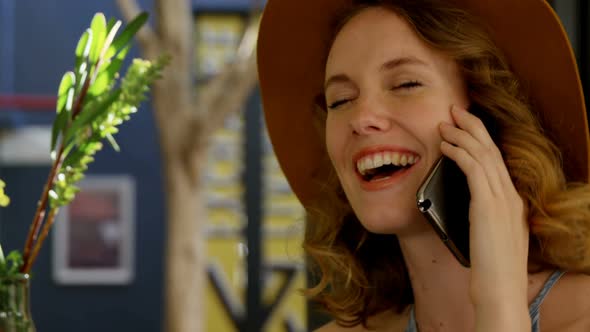 Smiling woman talking on the phone in cafe 4K 4k