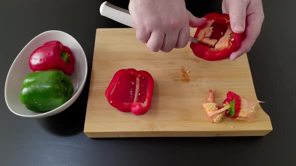 Ring seeds from a red bell pepper on a cutting board, medium shot overhead