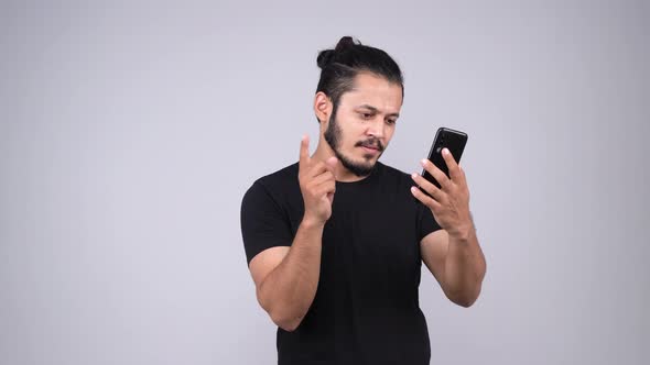 Indian man swiping left on smartphone