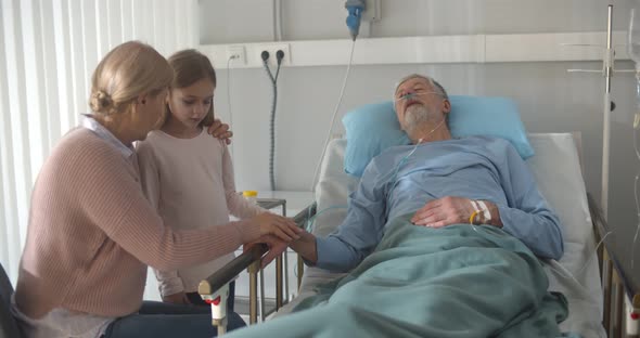 Upset Grandmother and Granddaughter Visiting Dying Patient in Hospital