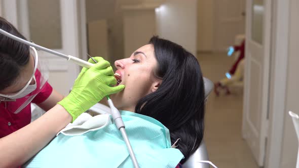 Woman at the Dental Hygienist Getting Professional Tooth Whitening and Ultrasound Cleaning