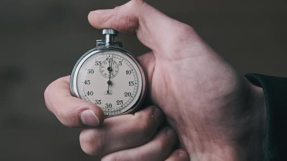 Stopwatch in Male Hand Counts Down Seconds