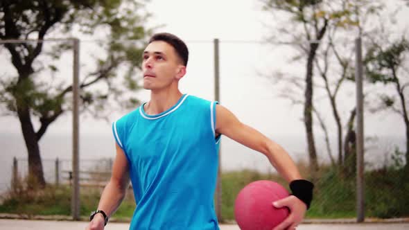 Young Man Running with a Ball and Throwing a Ball to the Basket Successfully