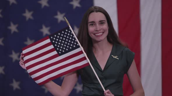 Young woman holding up American Flag and smiling